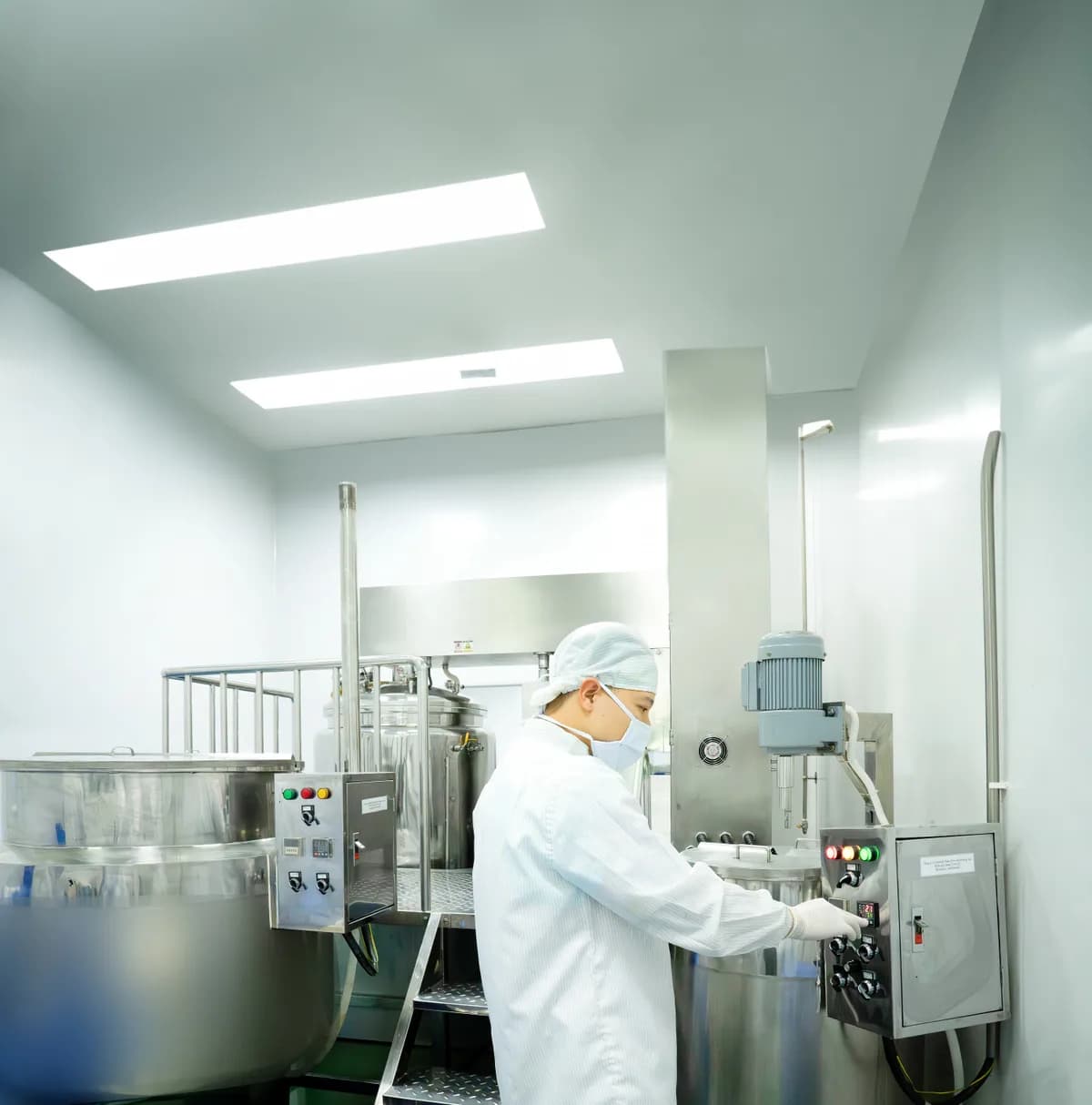 Nhân viên đứng cạnh một thiết bị inox